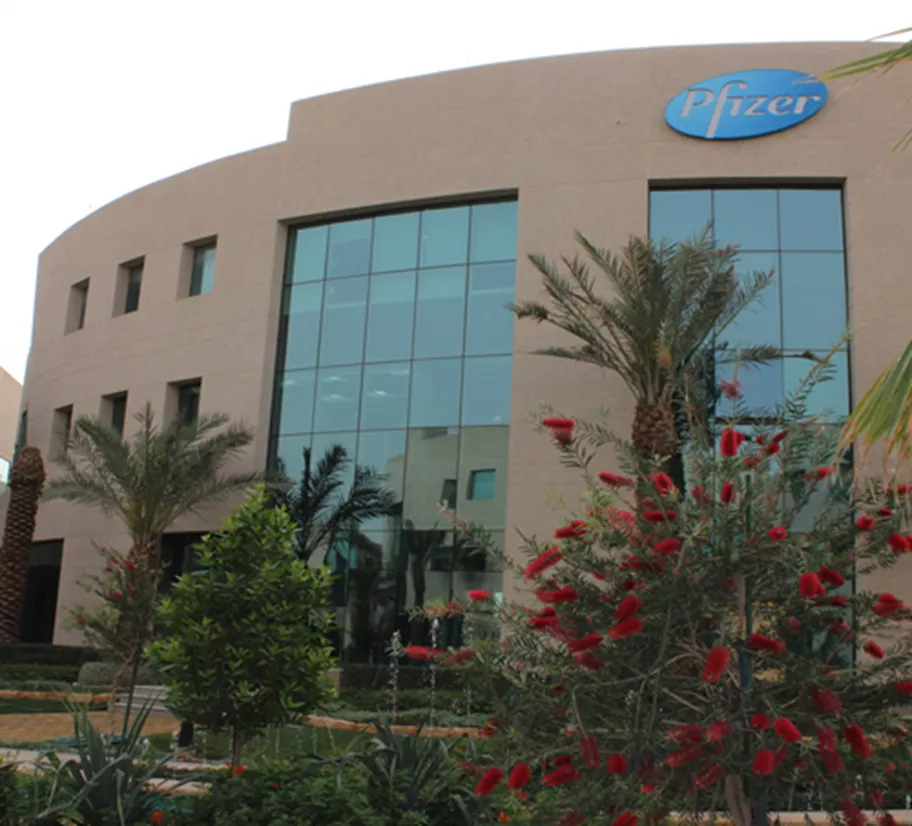 Located at The Business Gate building showcases a modern façade with large glass panels and is surrounded by lush landscaping, reflecting a professional and serene corporate environment.